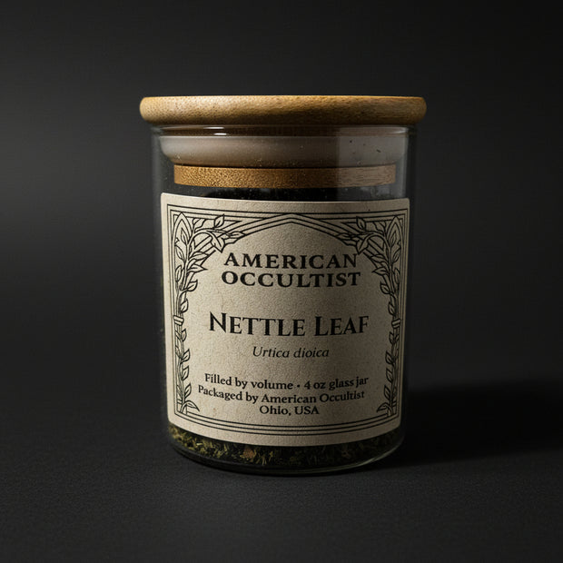 Dried cut-and-sifted nettle leaf (Urtica dioica) in a labeled glass ritual herb jar