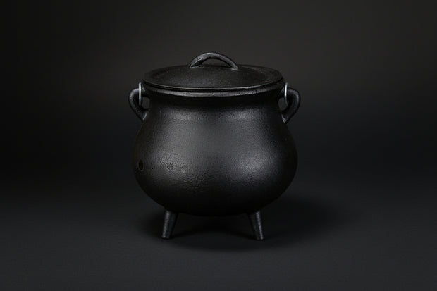 Plain black cast iron cauldron with three legs and lid