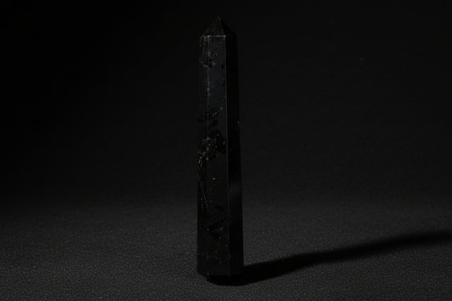 Black crystal held in a hand with 'CRG' branding.