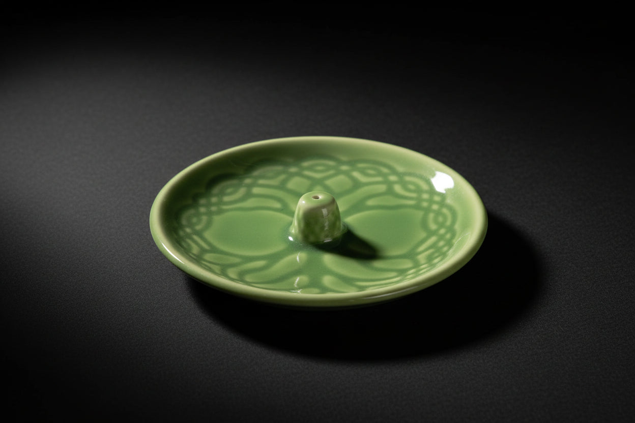 Green ceramic incense burner with decorative design on a white background