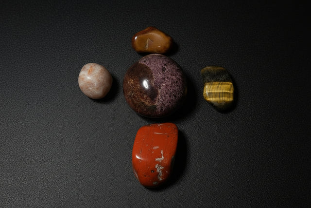 Collection of polished stones on a white sheet of paper with a wooden surface.