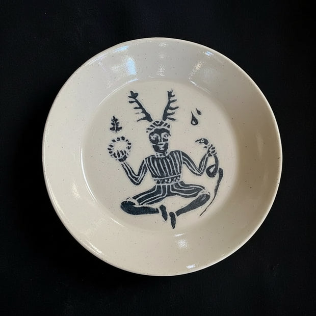 White ceramic plate with black decorative design on a dark background