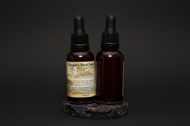 Dropper bottle with Dragon's Blood Oil in it on a black cloth.