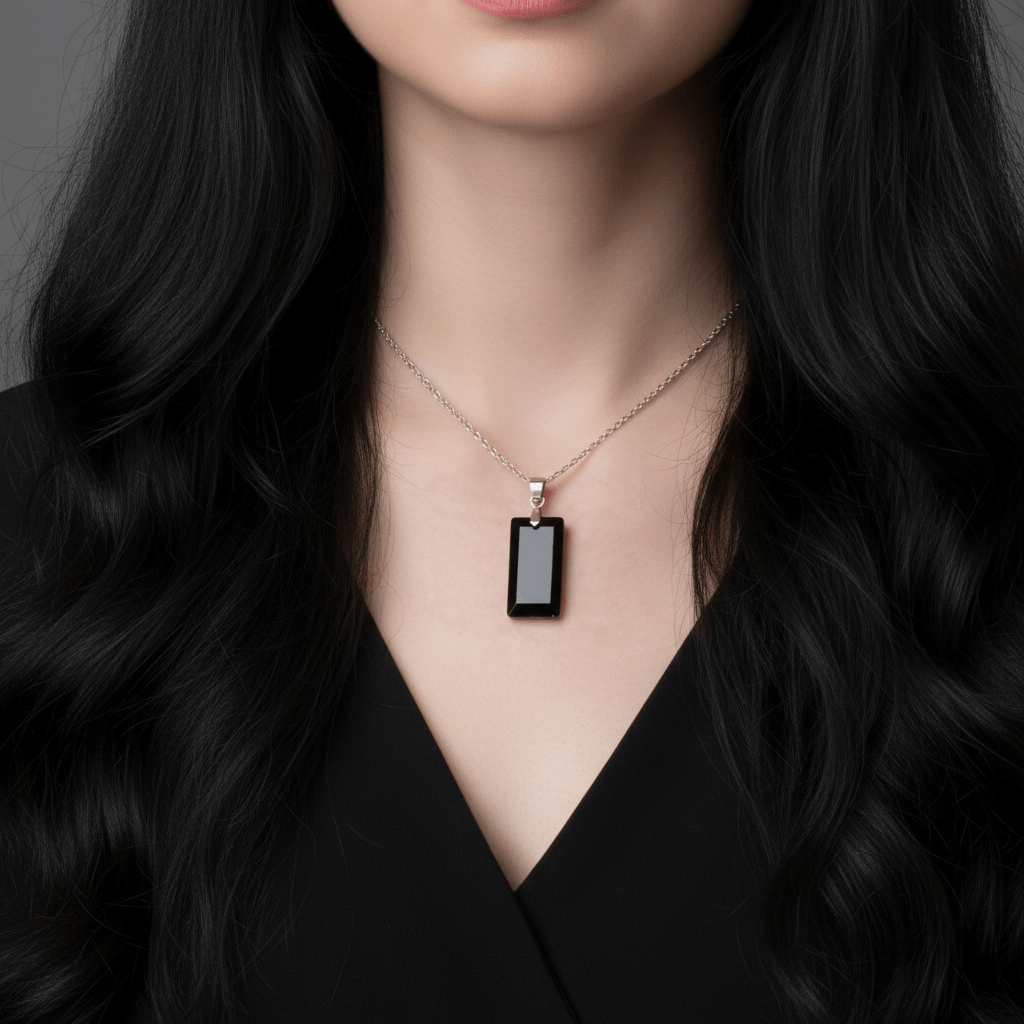 Woman wearing a black pendant necklace against a neutral background