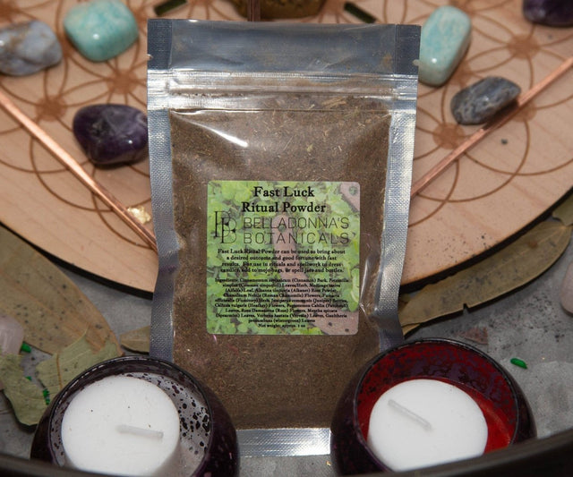 Packaged 'Fast Luck Ritual Powder' from Belladonna's Botanicals on a mystical background with stones and candles.