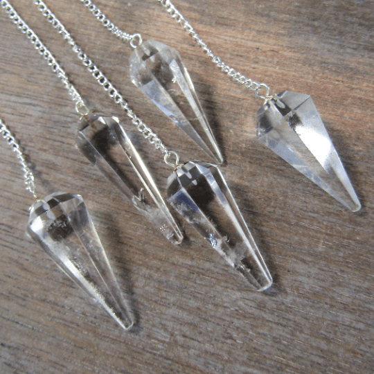 Crystal pendulums on a wooden surface