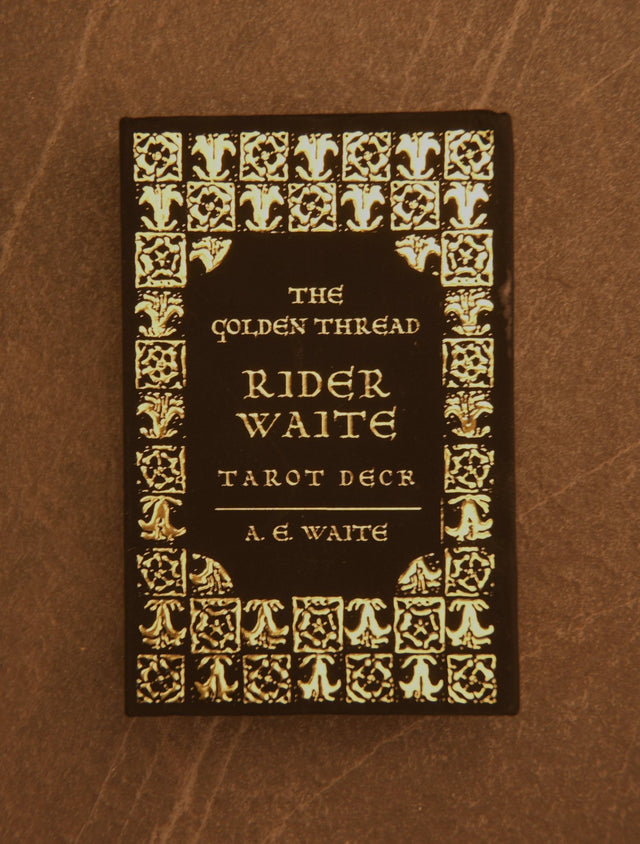 The image shows the cover of a tarot deck titled 'The Golden Thread Rider-Waite Tarot Deck'. The cover is dark with gold thread accents and decorative border.