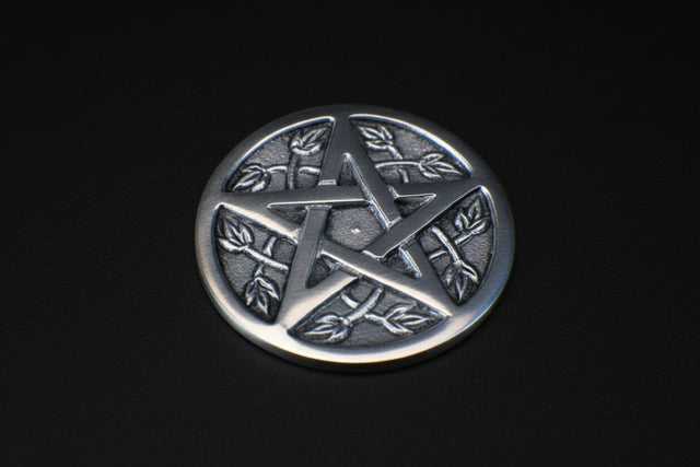 Silver pentagram pendant on a textured dark surface