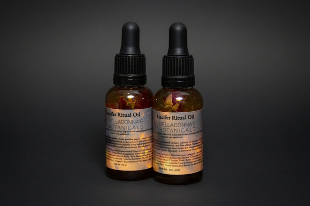Two bottles of Locifer Ritual Oil with botanicals on a dark background