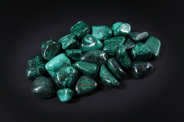 Collection of green tumbled stones on a wooden surface