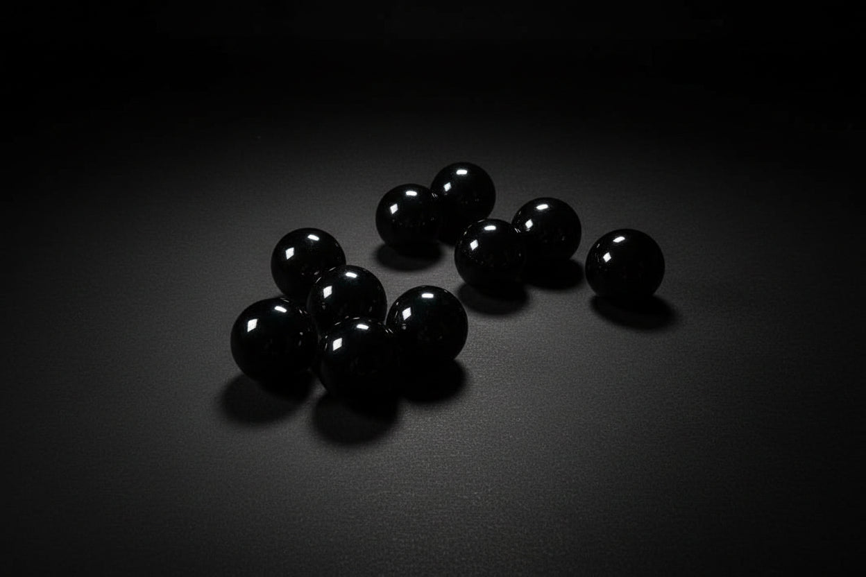 Black spherical objects on a wooden surface