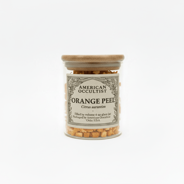 Jar of orange peels diced up with a wooden lid on a white background