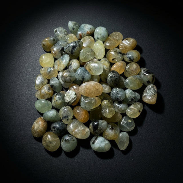 Collection of multicolored gemstones on a light wooden surface