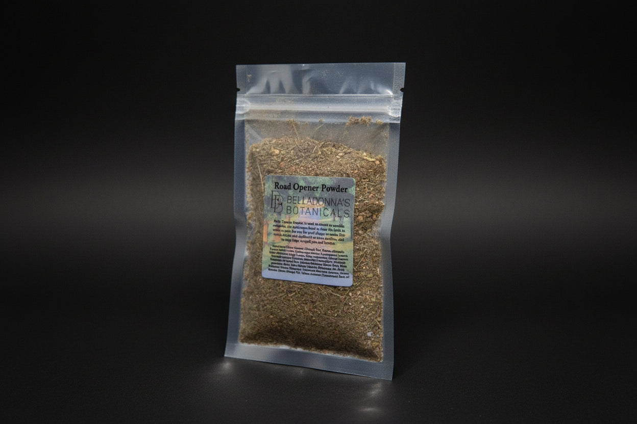 Packaged herb labeled 'Road Opener Powder' by Belladonna's Botanicals on a reflective surface with a candle in the background.