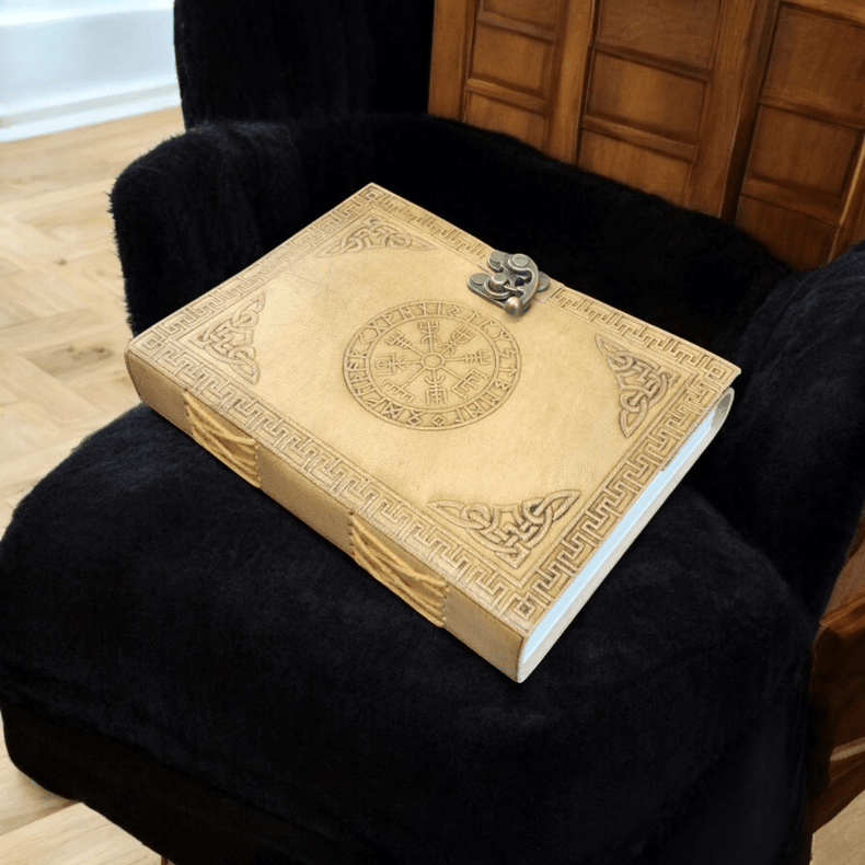 Decorative book with intricate designs on a black armchair