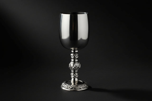 Silver goblet with intricate design on a white background