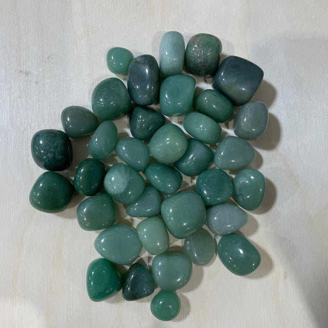Collection of greenish-blue stones on a light wooden surface