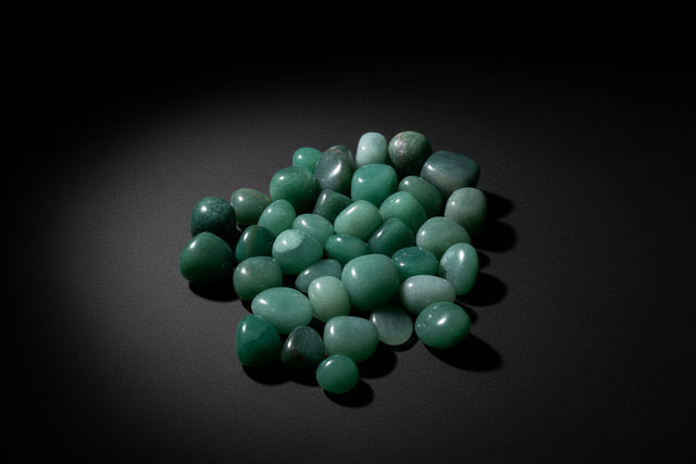 Collection of greenish-blue stones on a light wooden surface