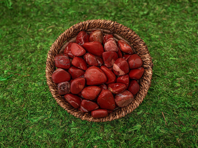 Wicker basket filled with red jasper stones on a green mossy background