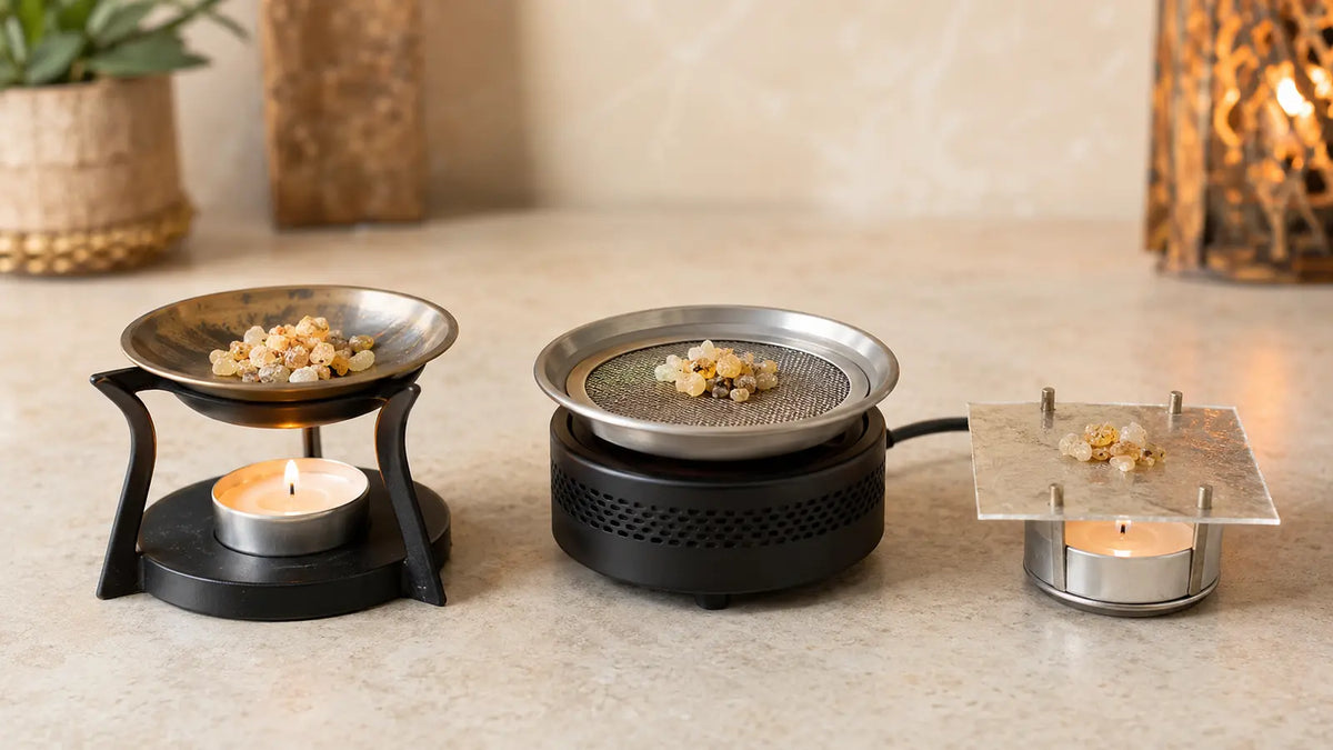 Candle-powered, electric, and mica-plate resin incense warmers arranged to compare methods that do not use charcoal