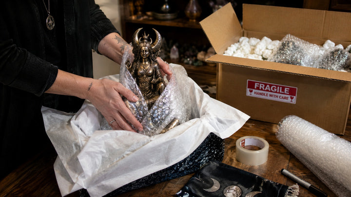 A compact portable altar kit being packed carefully with a few essential ritual objects.