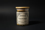 Dried German chamomile flowers (Matricaria chamomilla) in a labeled glass ritual herb jar