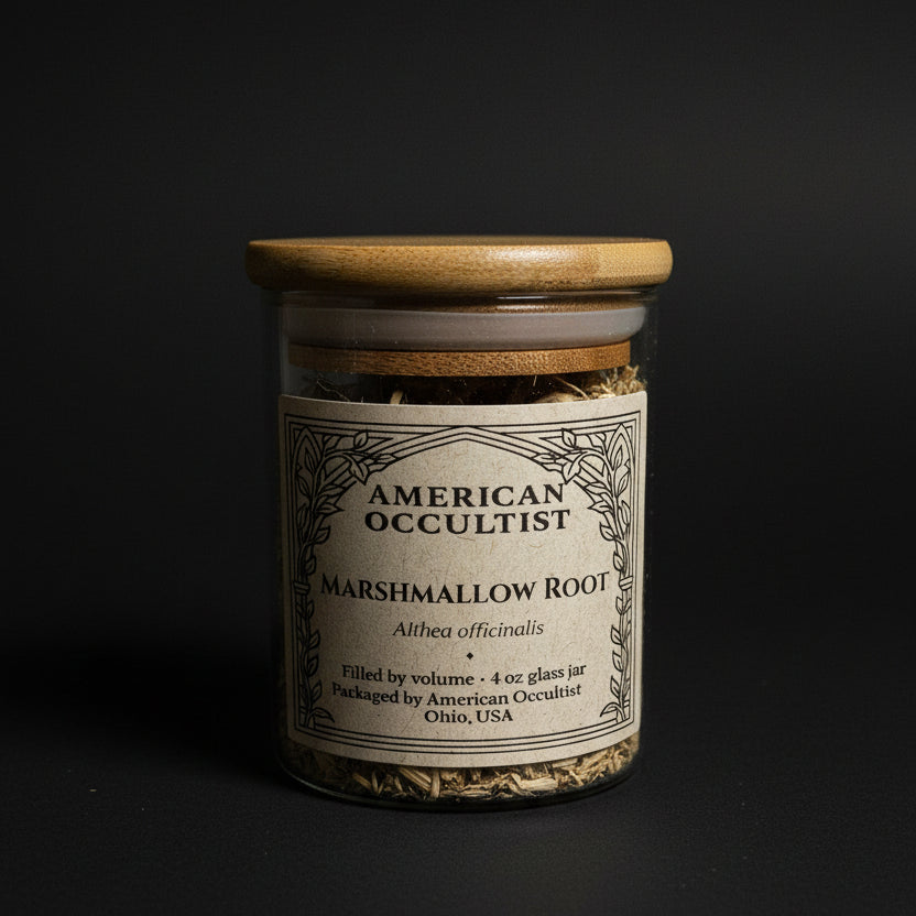 Bottle labeled 'American Occultist marshmallow root' on a marble surface with black cylindrical objects.