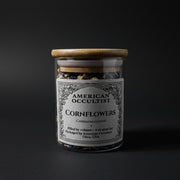 Whole dried cornflowers (Centaurea cyanus) in a labeled glass ritual herb jar