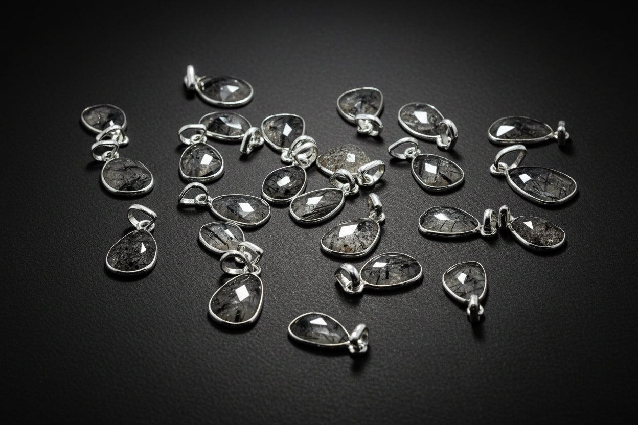Collection of silver teardrop pendants on a black background