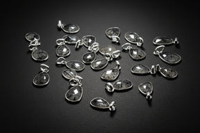 Collection of silver teardrop pendants on a black background