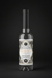 Two bottles of 'Protection' cleansing water with decorative labels on a black background
