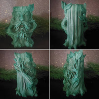 Green leafy decorative item against a dark background with greenery.