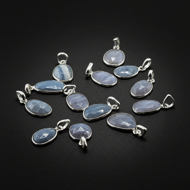 Collection of silver pendants with blue stone beads on a black background