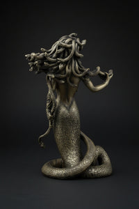 Statue of a woman with snake-like hair and body on a black background