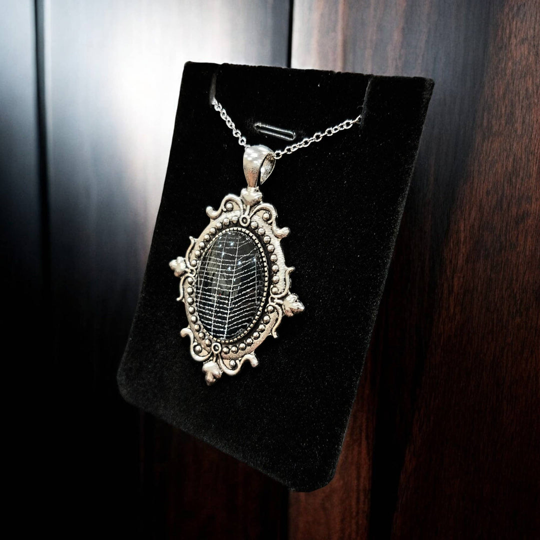 Side view of small silver-tone spiderweb filigree cabochon