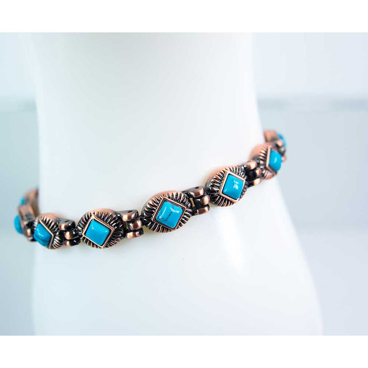 Detail of magnetic copper-tone bracelet with turquoise-colored accents