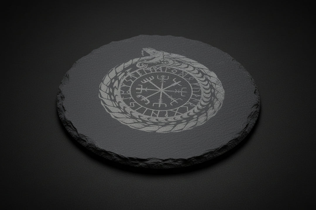 Round slate altar tile engraved with Nordic ouroboros and runic-style symbol used as a ritual surface.