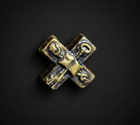 Bronze cross-shaped object on a black background