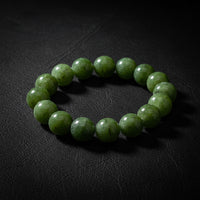  a green beaded bracelet on a dark black background.