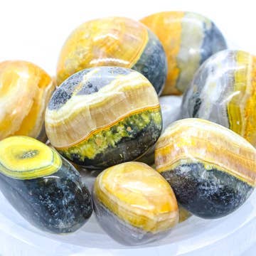 Close view of polished Bumble Bee Jasper stones with natural banding