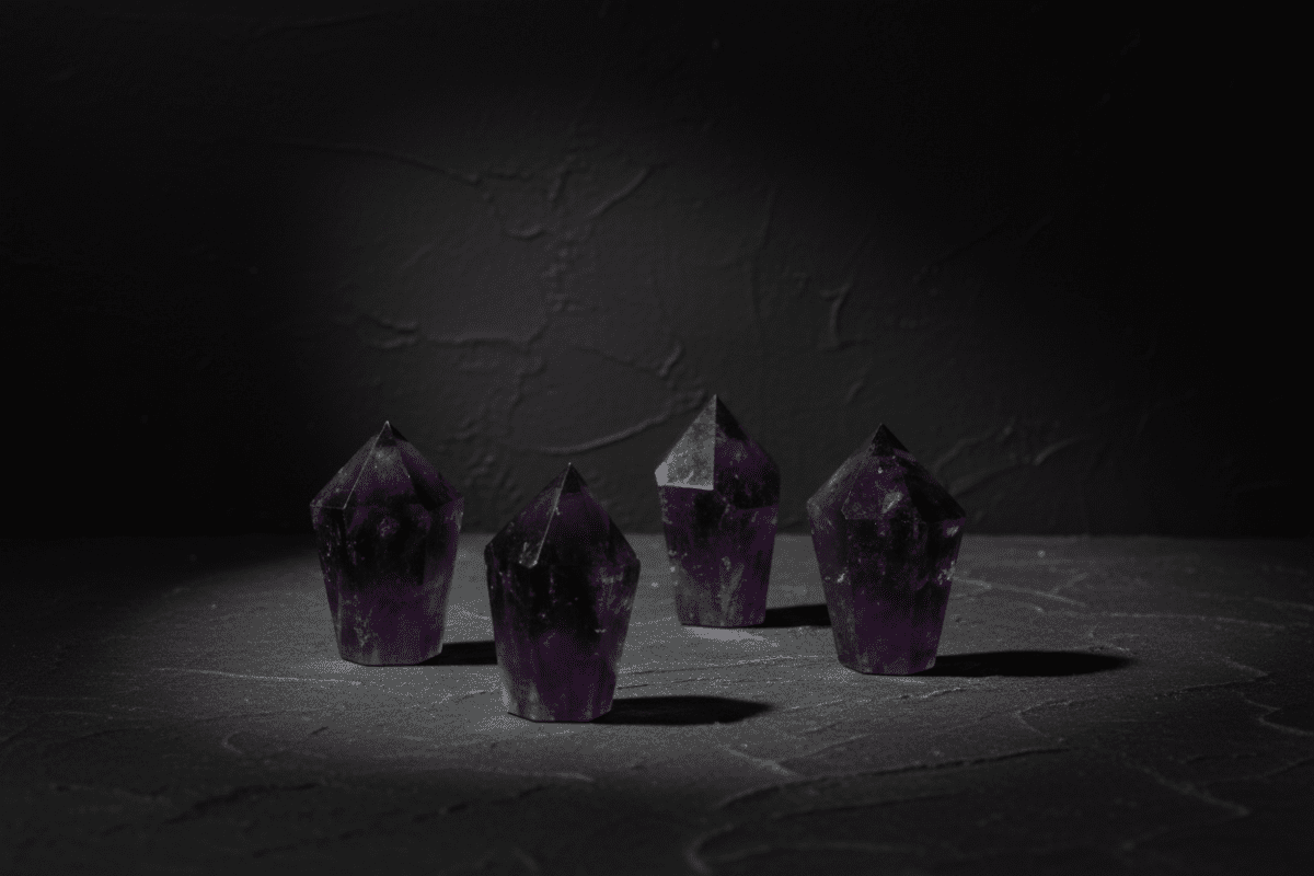 Polished dark-purple amethyst diamond obelisk with a faceted point
