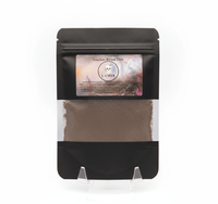 Black packaging of Ancestral Ritual Dust with a visible brand label on a white background