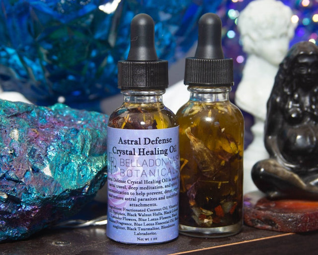 Two bottles of Astral Defense Crystal Healing Oil with droppers on a mystical background.