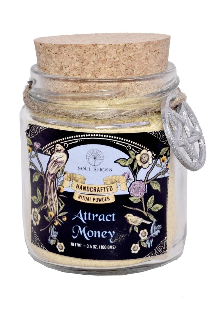 Jar of handcrafted ritual powder labeled 'Attract Money' with a cork lid on a white background.
