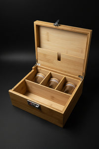 Opened large wooden stash box with lock, compartments, glass jar, and brush tool for organizing ritual supplies.