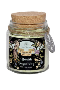 Jar of 'Banish Negativity' powder with decorative label and cork lid on a white background