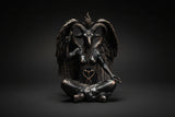 Bronze statue of a winged creature with a heart symbol on a white background