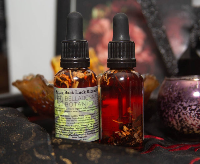 Two dropper bottles with herbal elements on a dark surface with a blurred background