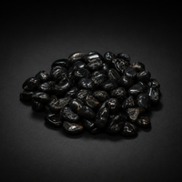 Pile of polished black stones sold as Black Onyx with subtle natural markings on a matte black surface