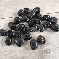 Black stones on a wooden surface
